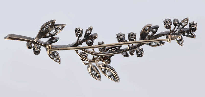 Брошь из желтого и белого металла, общим весом 18,27 грамма, содержит природные вставки из бриллиантов